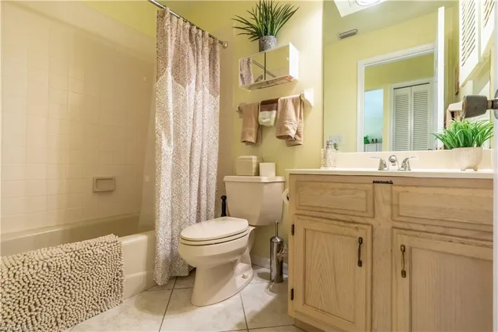 Full bathroom featuring vanity, toilet, shower / tub combo with curtain, and tile patterned flooring