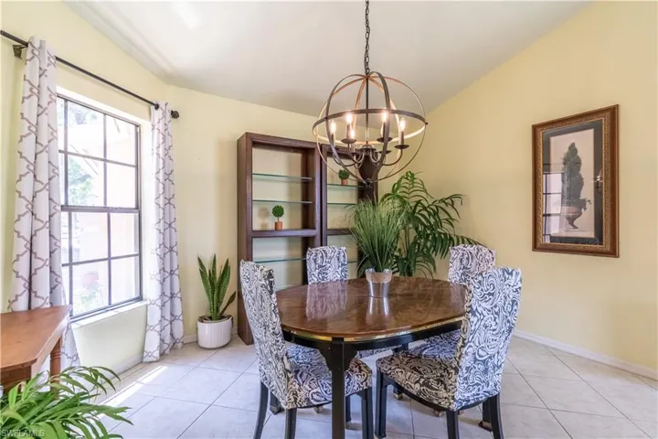 Tiled dining room with a notable chandelier