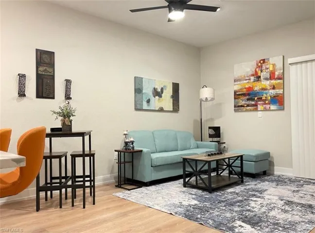 Living room with light wood-style flooring and ceiling fan