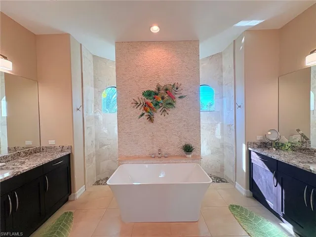 EXQUISITE!  DEEP SOAKING TUB WITH STONE ACCENT WALL, HIS / HER SEPARATE VANITIES, SEP. WATER CLOSET AND NICE WALK THRU SHOWER