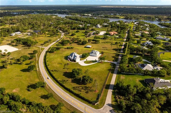 Birds eye view of property with a water view and a wooded view