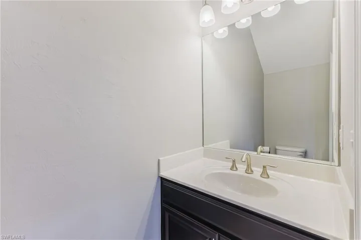 Bathroom with vanity and lofted ceiling