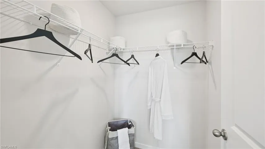 Model Home. Closet with white wire shelving and hanging rods