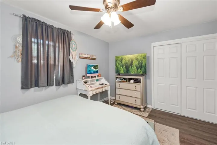 Bedroom featuring dark wood-style floors, a ceiling fan, and a closet