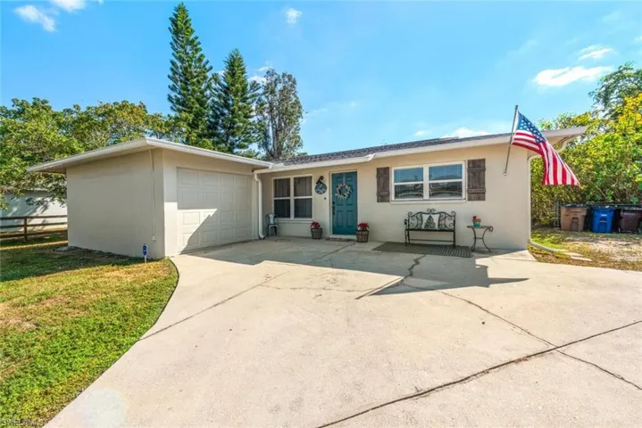 View of front of property with an attached garage, driveway, and stucco siding