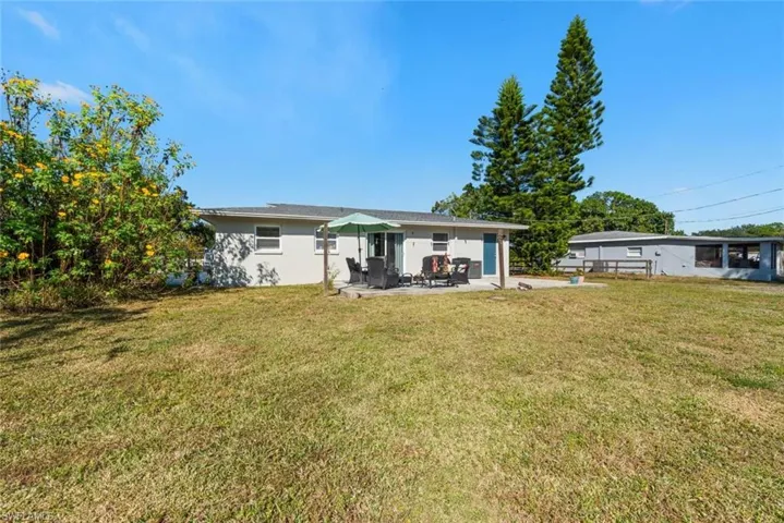 Rear view of property featuring a patio area and a lawn