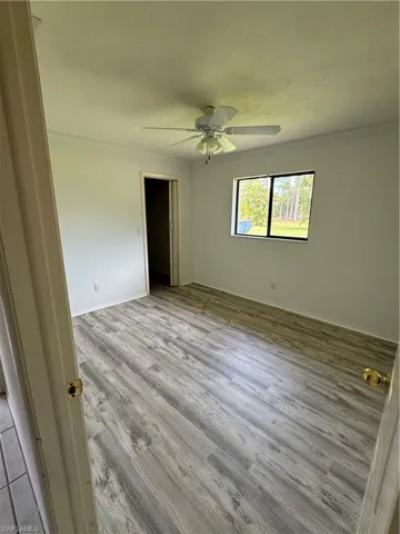 Unfurnished bedroom featuring light wood-type Vinyl plank flooring, ceiling fan, and a closet