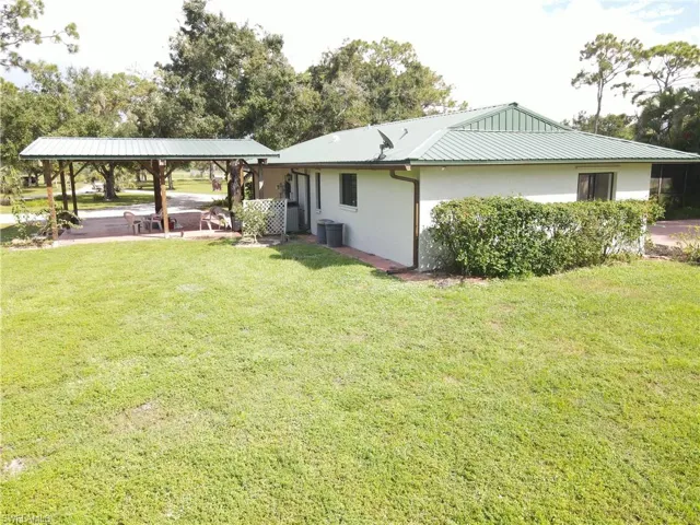 Back of house with a patio, stucco siding, and a yard
