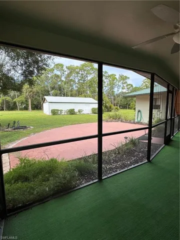 Inside screened lanai looking out to outdoor patio area.