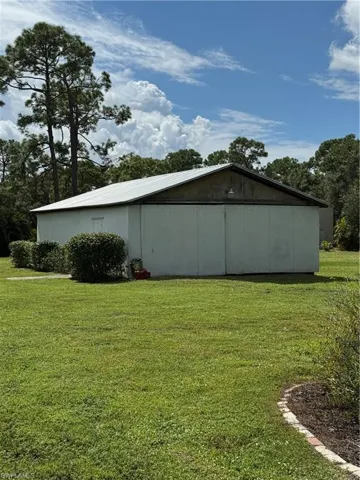 View of pole building with a yard