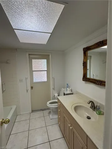 Bathroom featuring vanity, light tile patterned floors, and bathing tub / shower combination