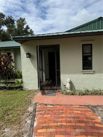 Entrance to property with stucco siding and a metal roof