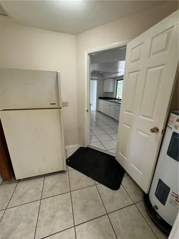 Utility area, with refrigerator, hot water heater. This was originally the garage and now leads to laundry area.  There is a small step up going into the house.