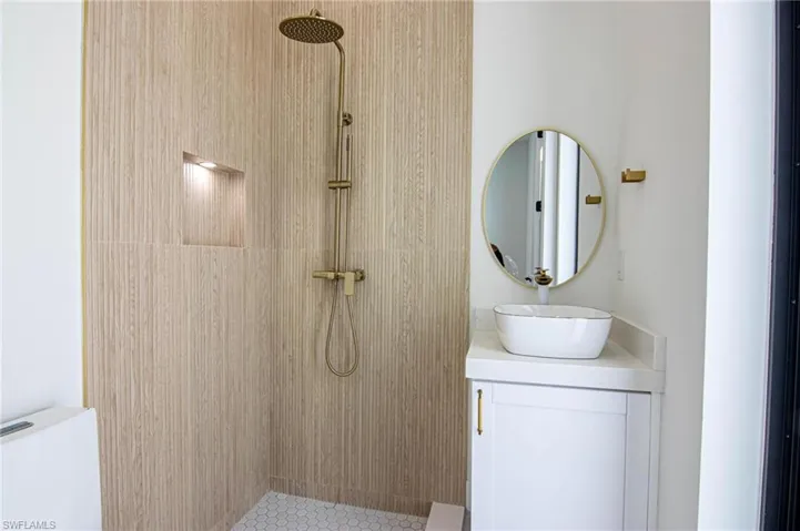 Full bathroom with tiled shower and vanity