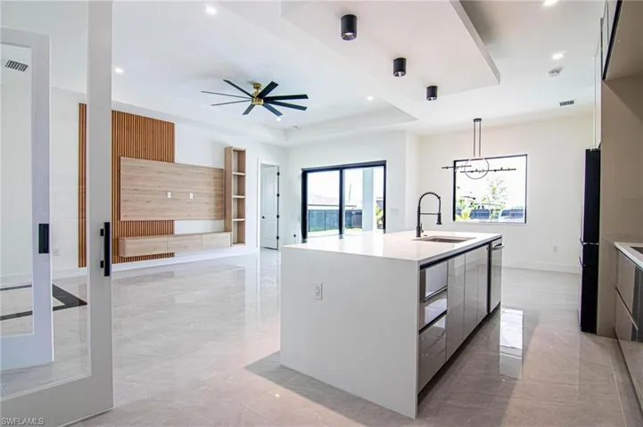 Kitchen featuring modern cabinets, light marble finish flooring, ceiling fan, light countertops, and recessed lighting
