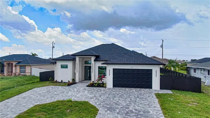 View of front of property featuring stucco siding, a garage, decorative driveway, and a shingled roof