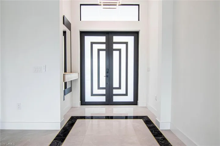 Entrance foyer featuring inlaid floor details, plenty of natural light, and marble finish flooring
