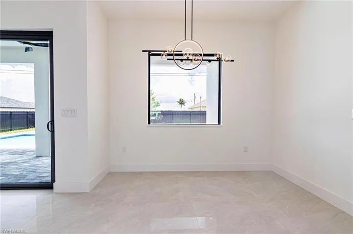Empty room with a chandelier and baseboards