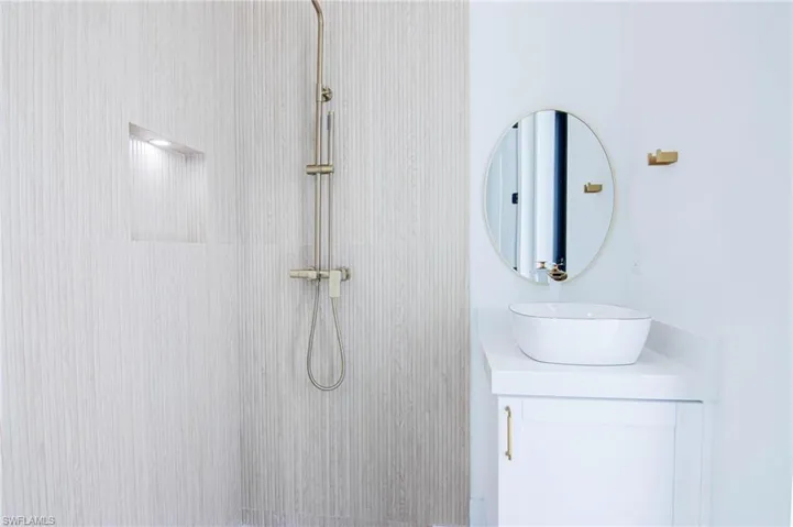 Full bath with vanity and a tile shower