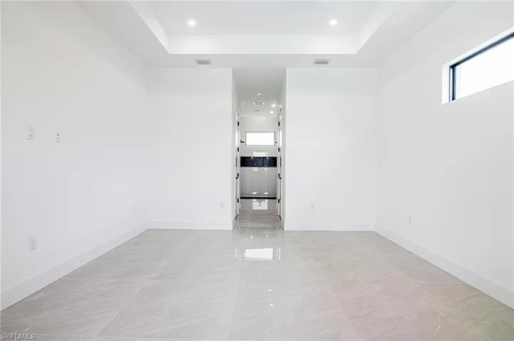 Spare room featuring a raised ceiling and recessed lighting