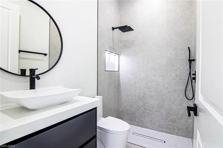 Bathroom featuring tiled shower and vanity