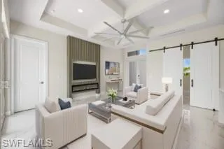 Tiled living room with beamed ceiling, a barn door, and coffered ceiling