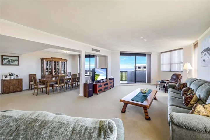 Living room featuring light carpet and crown molding