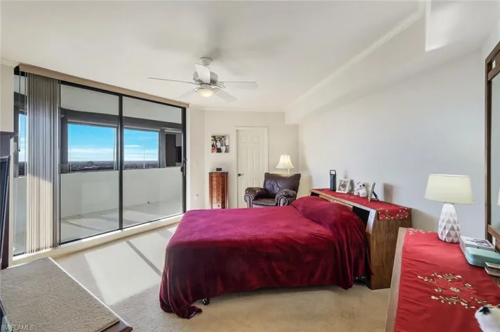 Carpeted bedroom featuring ceiling fan, crown molding, and access to outside