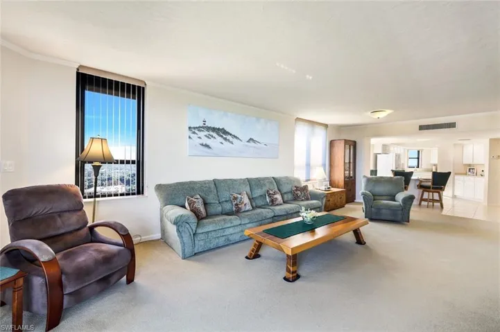 Carpeted living room featuring crown molding