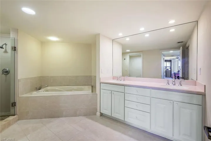 Bathroom with tile patterned floors, vanity, and independent shower and bath