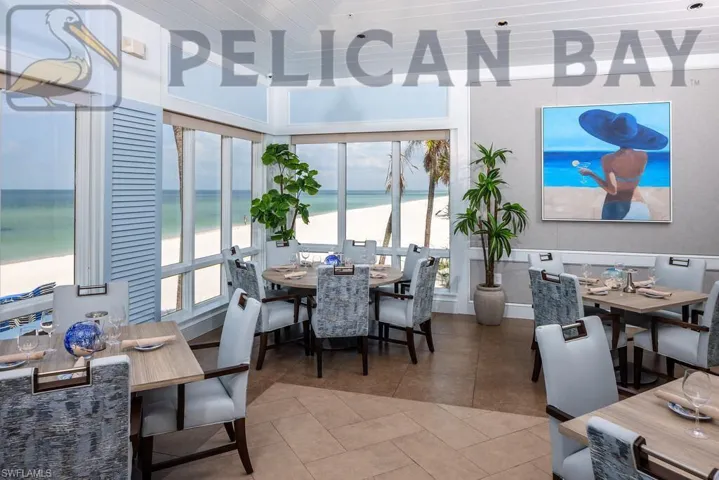 Tiled dining room with a wealth of natural light, a water view, and a view of the beach