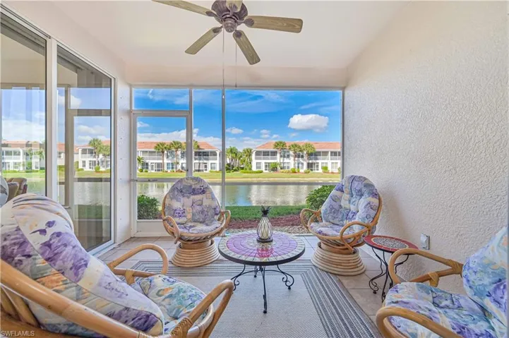 Sunroom featuring a textured wall, tile patterned flooring, healthy amount of natural light, and a water view