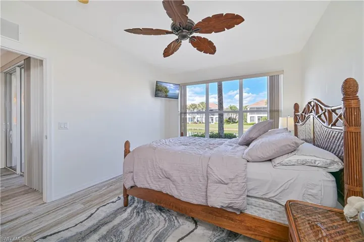 Bedroom featuring lofted ceiling, light wood-style flooring, and a ceiling fan
