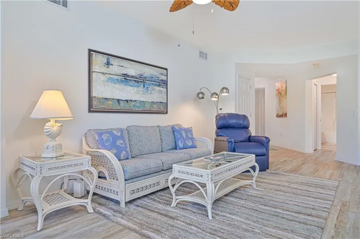 Living area with light wood-style flooring and a ceiling fan