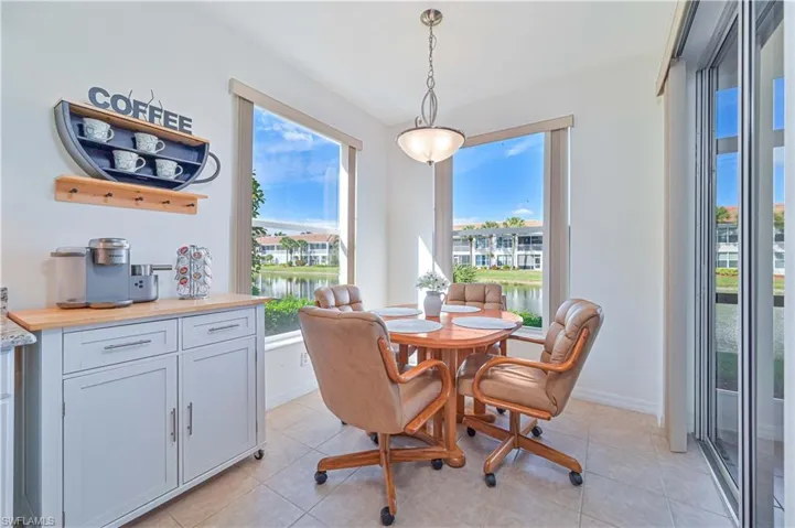 Dining room featuring light tile patterned flooring and a water view