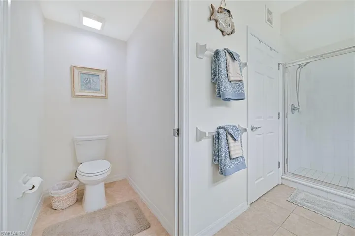 Full bathroom with light tile patterned floors and a shower stall