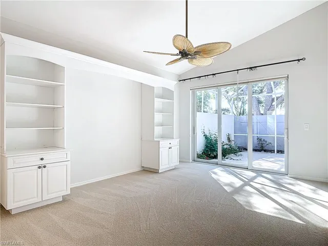 Spare room featuring ceiling fan, vaulted ceiling, and light colored carpet