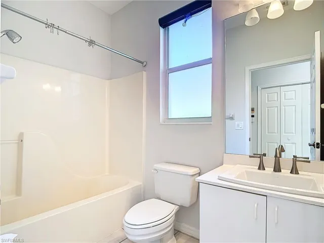 Full bathroom with tile floors, vanity, toilet, and bathtub / shower combination
