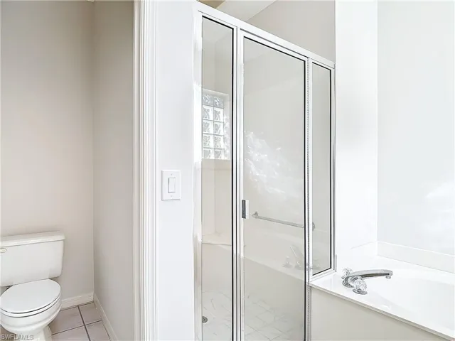 Bathroom with tile floors, toilet, and independent shower and bath