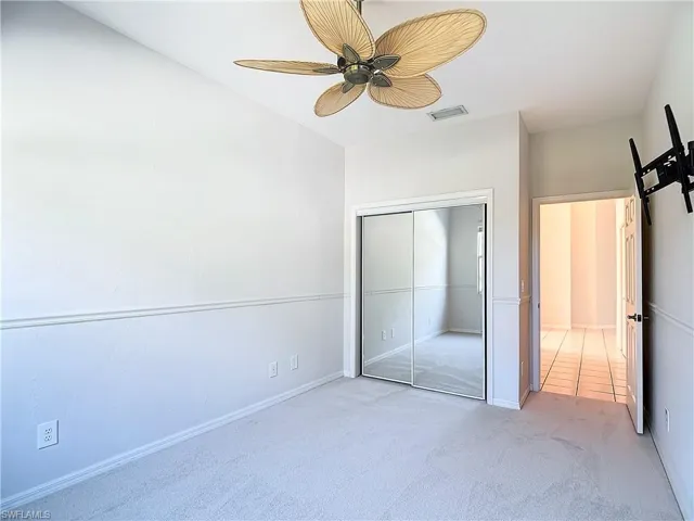 Unfurnished bedroom featuring carpet flooring, a closet, and ceiling fan