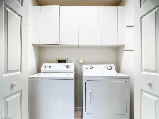 Laundry area with independent washer and dryer, cabinets, and washer hookup