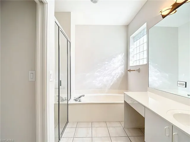 Bathroom featuring tile flooring, separate shower and tub, and large vanity