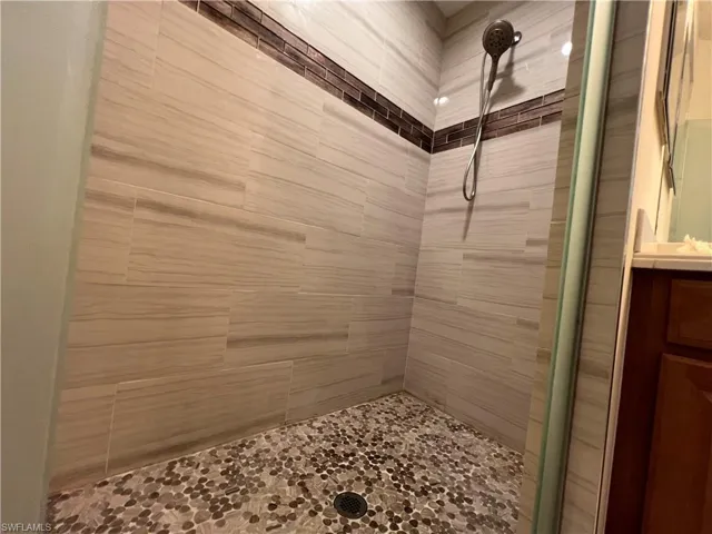 Master Bathroom with vanity and a tile shower with stome floor