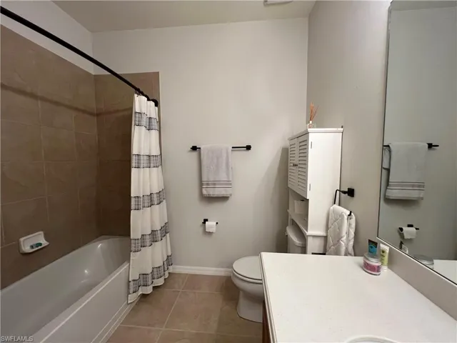 Guest Full bathroom featuring vanity, tile patterned flooring, toilet, and shower / bathtub combination with curtain