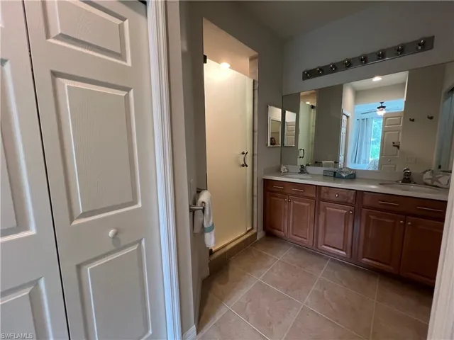 Master Bathroom with vanity, an enclosed shower, ceiling fan, and tile patterned floors