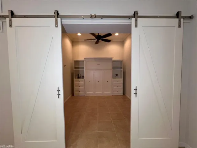 Den with Barn Doors & Murphy bed, tile patterned flooring