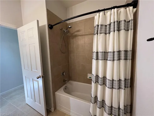 Guest Bathroom featuring tile patterned floors and shower / bath combo with shower curtain