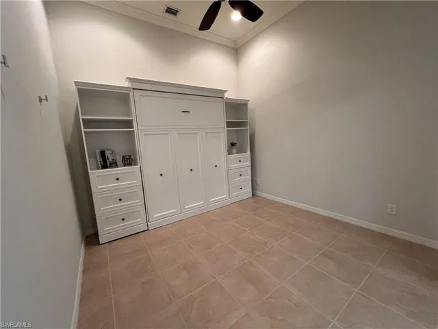 Den/bedroom featuring crown molding, light tile patterned flooring, and ceiling fan