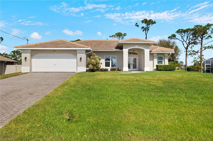 View of front facade featuring a front lawn and a garage