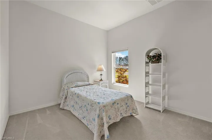 Bedroom featuring light carpet and lofted ceiling